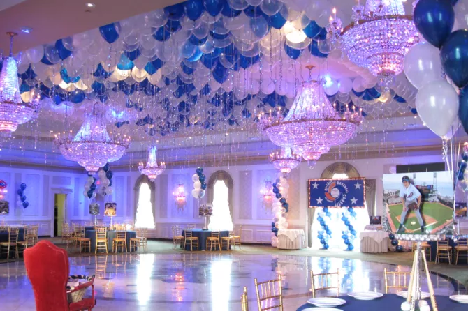 Use balloons to brighten a plain ceiling by combining them with chandeliers that compliment the balloons.