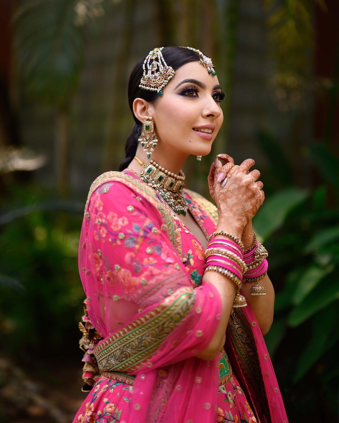 Photo of Mehendi bridal look in peach lehenga with unique earrings